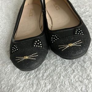 Shinny black flats with cat face on the front